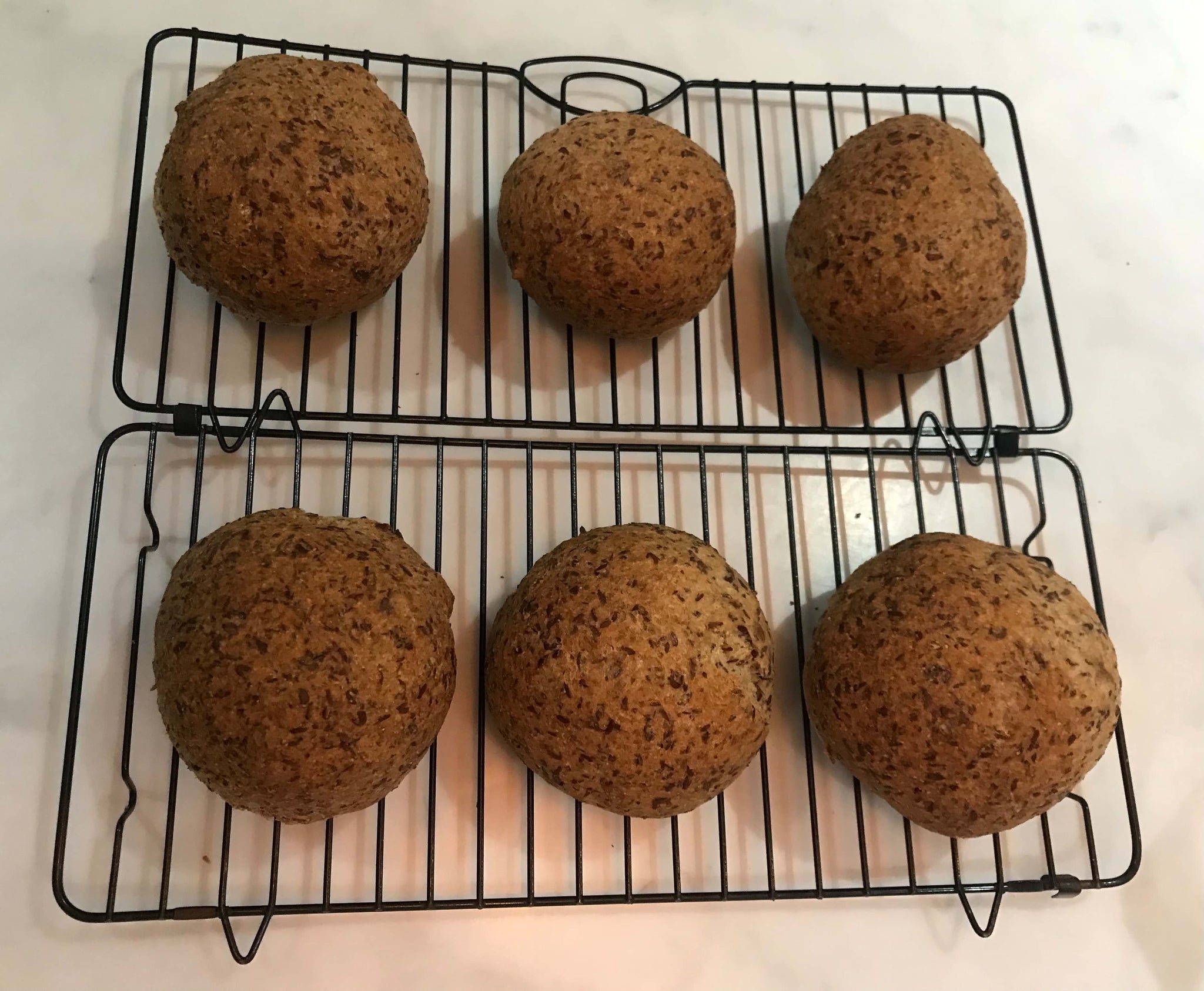 6 essential bread rolls fresh from the oven, cooling down on a on a cooling rack. 